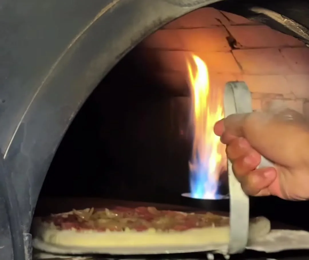 A pizza entrando no forno